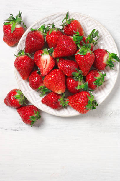 istock Fresh strawberries in plate on white wood 1144288898