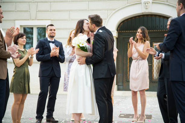 istock Guests clapping and looking the bride and groom kissing 1144289530