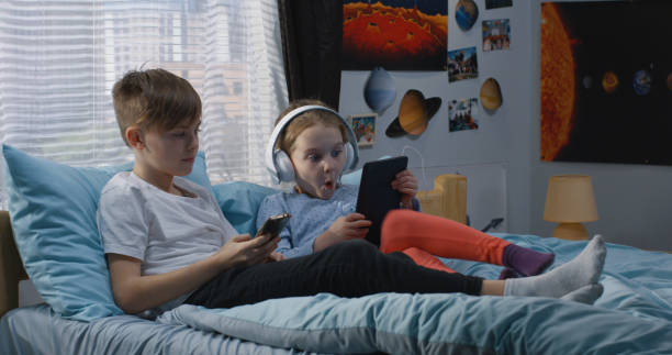 istock Boy and girl relaxing together on bed 1144293930