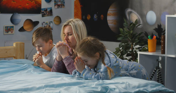 mutter und kinder beten gemeinsam - praying joy indoors lifestyles stock-fotos und bilder