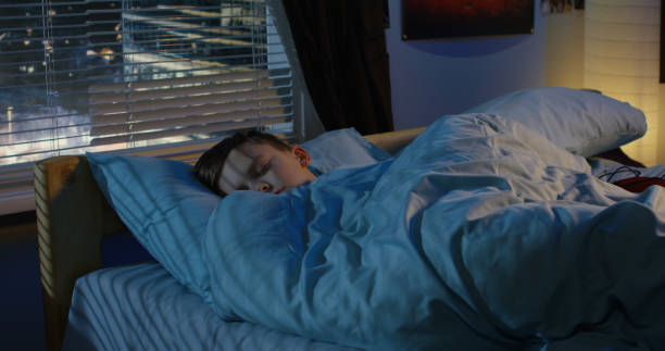 彼のベッドで眠っている少年 - 睡眠 ストックフォトと画像
