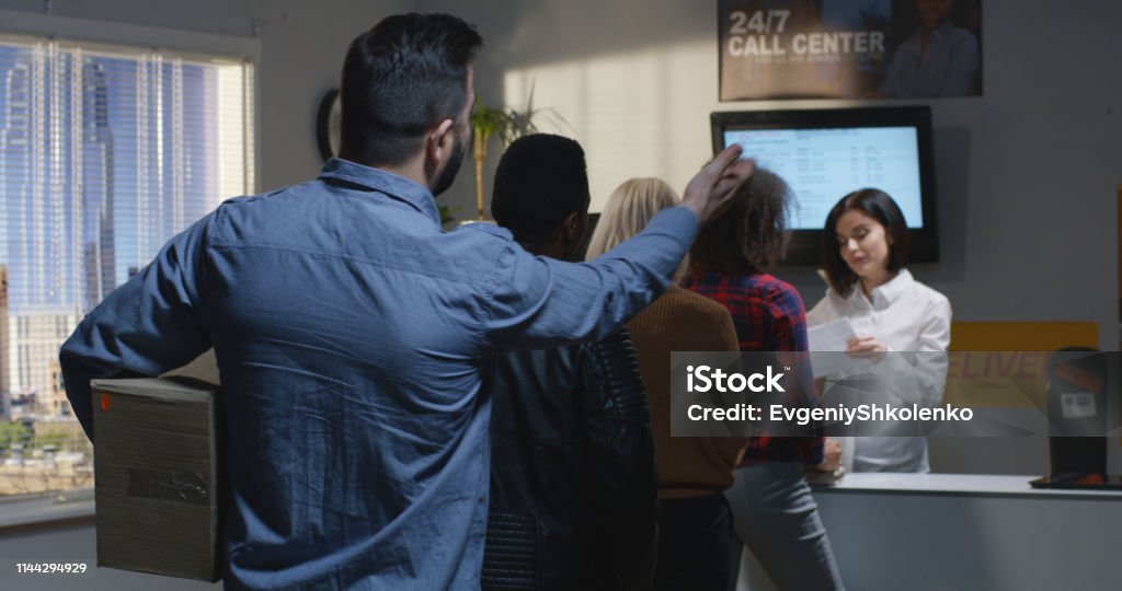 Customer complaining about slow service in delivery center Medium shot of an impatient customer standing in queue and complaining about slow service in delivery center Impatient Stock Photo