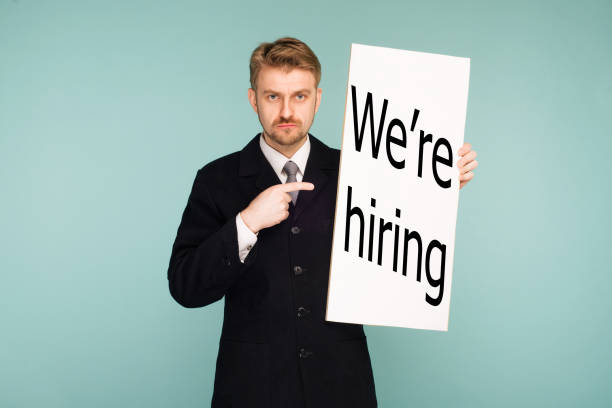 istock Happy smiling young business man points finger signboard 1144296073