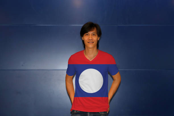 istock Man wearing Laos flag pattern shirt standing on the blue wall background. 1144296609