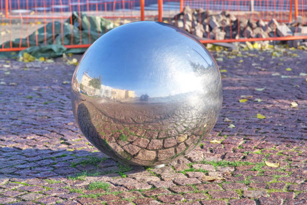 istock Paved granite pavement is reflected in a metal ball on a sunny day 1144297260