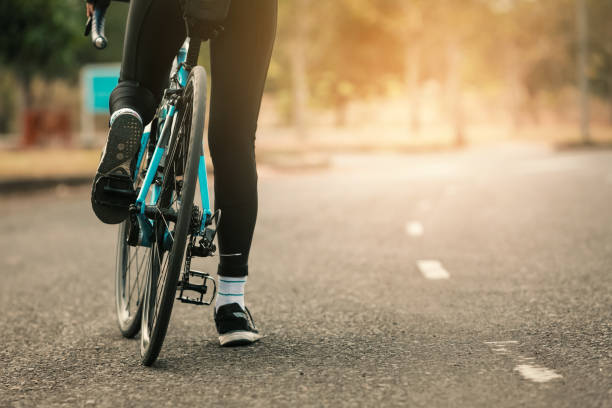 istock Low Section Of Woman Riding Bicycle On Road 1144298211