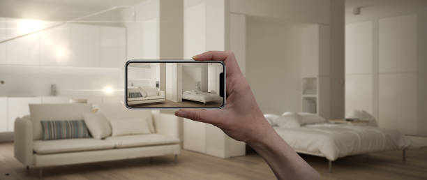 istock Hand holding smart phone, AR application, simulate furniture and interior design products in real home, architect designer concept, blur background, modern one room apartment 1144298915