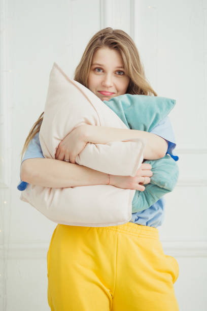 istock Just woken up girl without make up stands with pillows 1144300467