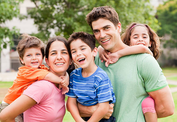 istock Young children ride piggyback on their parents 114430080