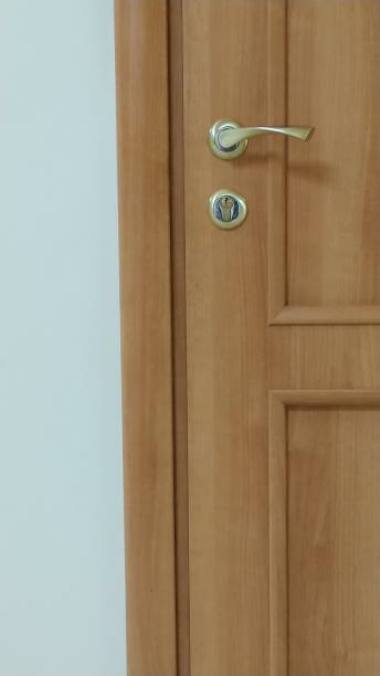 istock Door handle and blocking lock on a dark wooden door. Close-up. 1144301864