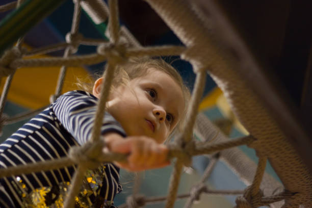 istock Active young girl climbing the spider web playground activity 1144305705