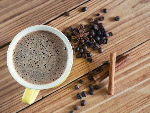 istock Yellow cappuccino coffee mug on wooden background with cinnamon 1144307639