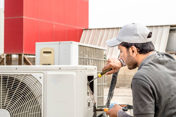 un profesional de un electricista reparador está reparando un aire acondicionado central de servicio pesado unirse en la parte superior del techo - oficio en servicios fotografías e imágenes de stock