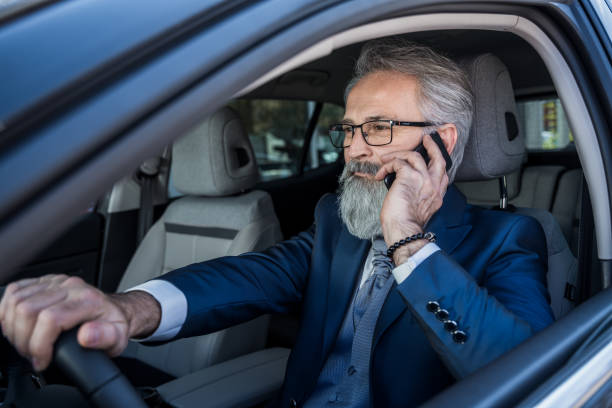 istock Classy dressed businessman using smart phone in car 1144311861