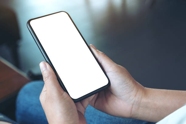istock Mockup image of woman's hands holding black mobile phone with blank white screen in cafe 1144312196
