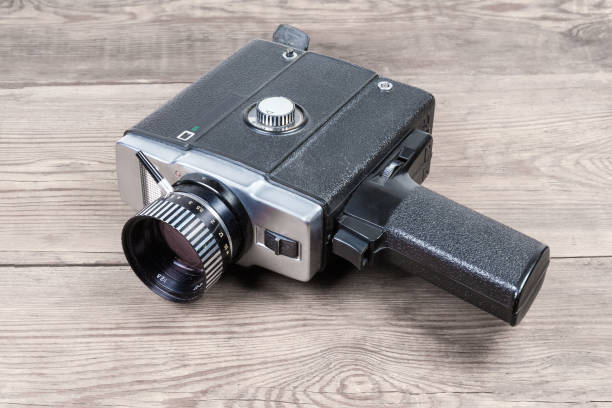 Vintage amateur electric movie camera on an old wooden surface Vintage amateur film movie camera powered by electric motor on an old wooden surface vintage amateur movie camera stock pictures, royalty-free photos & images