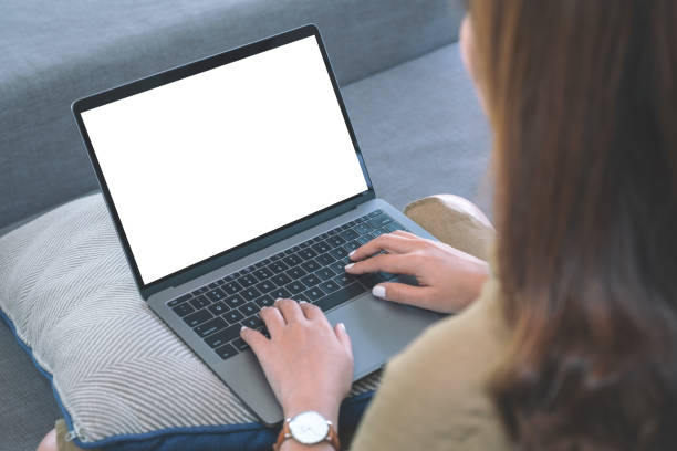 istock Mockup image of a woman using and typing on laptop keyboard with blank white screen while sitting in living room 1144312882