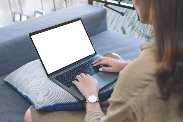 istock Mockup image of a woman using and typing on laptop keyboard with blank white screen while sitting in living room 1144312918