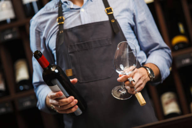 istock Male sommelier and just opened bottle with red wine 1144315702