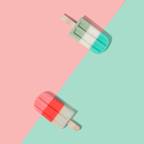 Ice cream popsicles in pastel pink and blue colors on paper duotone background.