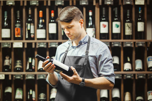 istock Young sommelier holding bottle of red wine in cellar 1144315864