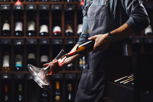 istock Bartender pours red wine in transparent vessel in cellar 1144316197