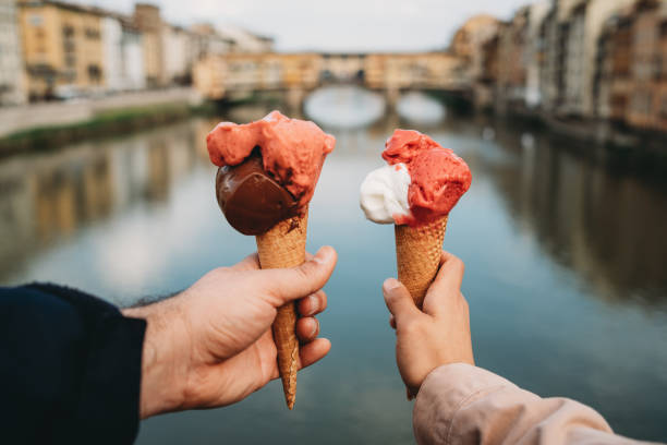 young couple eating an ice-cream in florence, italy - bridge people fun river imagens e fotografias de stock