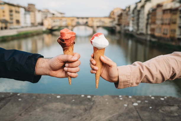 joven pareja comiendo un helado en florencia, italia - gelato cream ice cream ice fotografías e imágenes de stock