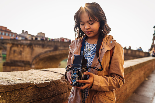 Young woman photographer with a vintage camera in the city