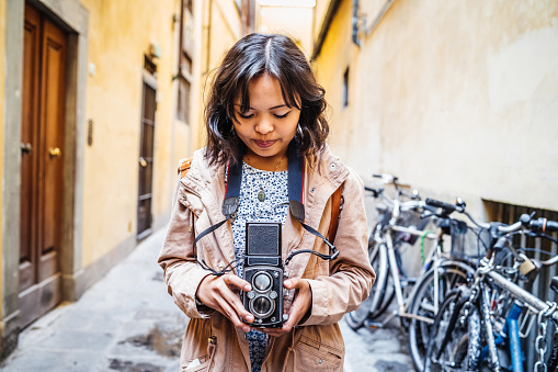 Young woman photographer with a vintage camera in the city