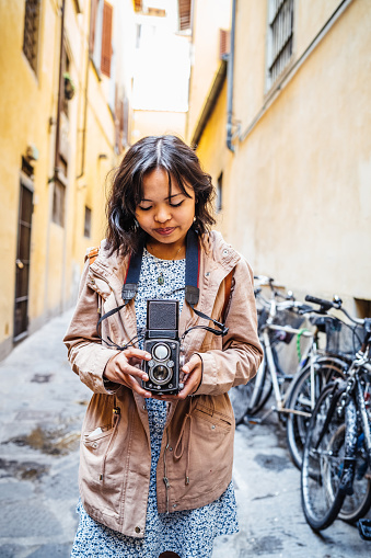 Young woman photographer with a vintage camera in the city