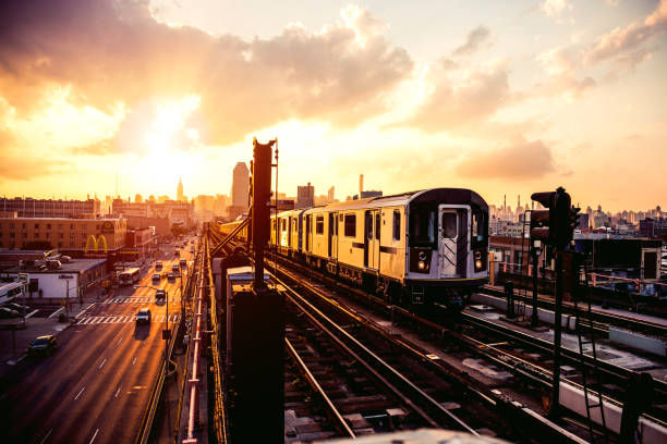 train de métro de new york approchant la plate-forme de station dans le queens - new york city sunrise new york state usa photos et images de collection