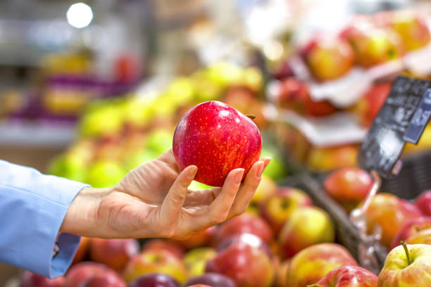 istock Women hand choosing apple at supermarket 1144321199