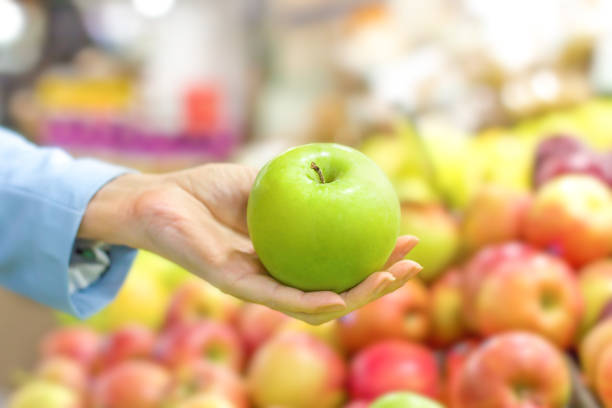 istock Women hand choosing apple at supermarket 1144324450