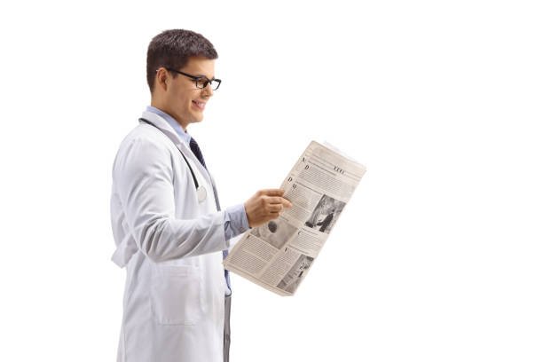istock Young doctor standing and reading a newspaper 1144326034