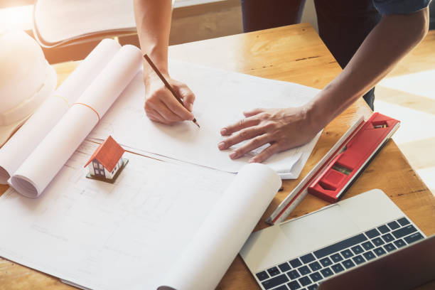 istock Architect or engineer working in office with blueprints,engineer inspection in workplace for architectural plan,sketching a construction project ,selective focus,Business construction concept. 1144330480