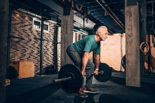 istock Active senior male doing a deadlift exercise in a gym gym 1144330843