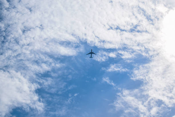 istock Airplane silhouette in the sky with clouds around 1144331084