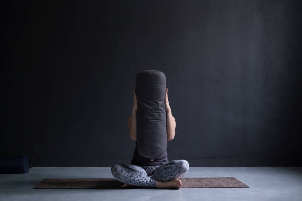 istock woman doing yoga at studio hiding her face with bloster. 1144333416