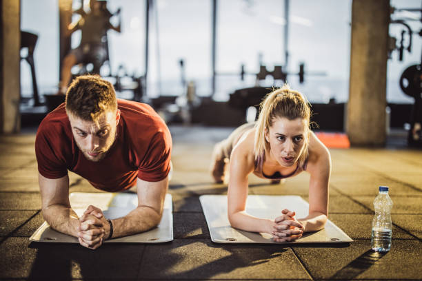 istock Athletic couple exercising strength in plank position at gym. 1144333558