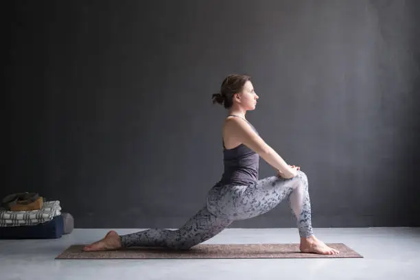 Photo of Woman doing Hatha yoga asana Anjaneyasana or low crescent lunge pose isolated,