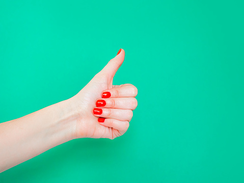 The Thumbs Up Sign. Like Hand Sign. Used when you want to demonstrate that you like something or that you approve of something, The ol thumbs up hand sign. Female hand with red manicure on fingernails holding hand in gesture of likeness giving thumb up on