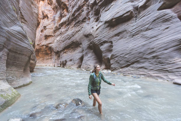 istock Female hiker wading through a Utah slot canyon 1144336523