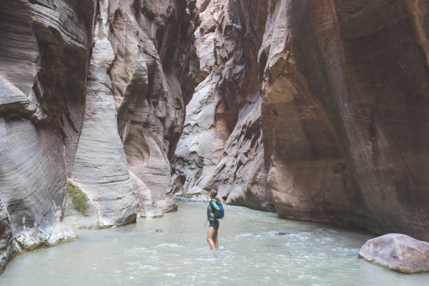 istock Female hiker wading through a Utah slot canyon 1144336526