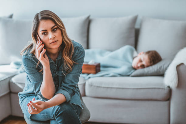istock Photo of Mother checking son's temperature  while talking with doctor 1144337512