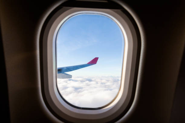 istock Plane wing view from inside plane in midair with blue sky cloud background 1144338726