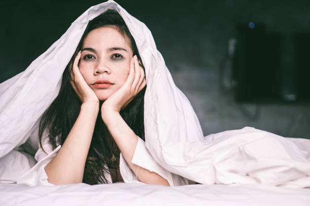 istock sleepless Asian woman lying down on bed and tired 1144339543
