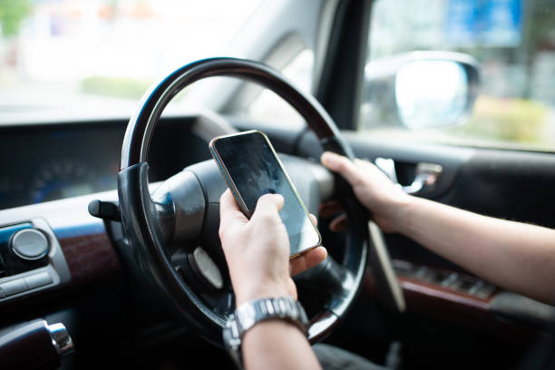 istock Male hand driving while operating a smartphone 1144343200