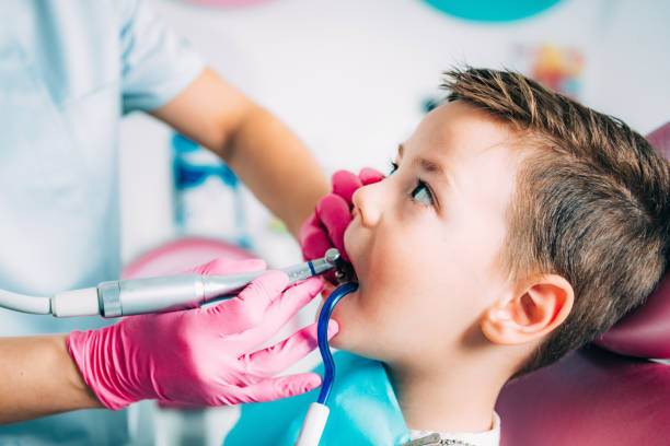 istock Child dentistry. Female dentist working with school boy 1144346418