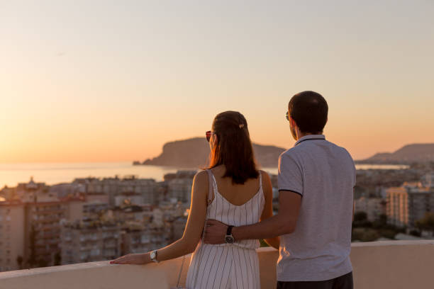istock Young couple watching sunset from the rooftop terrace 1144347705